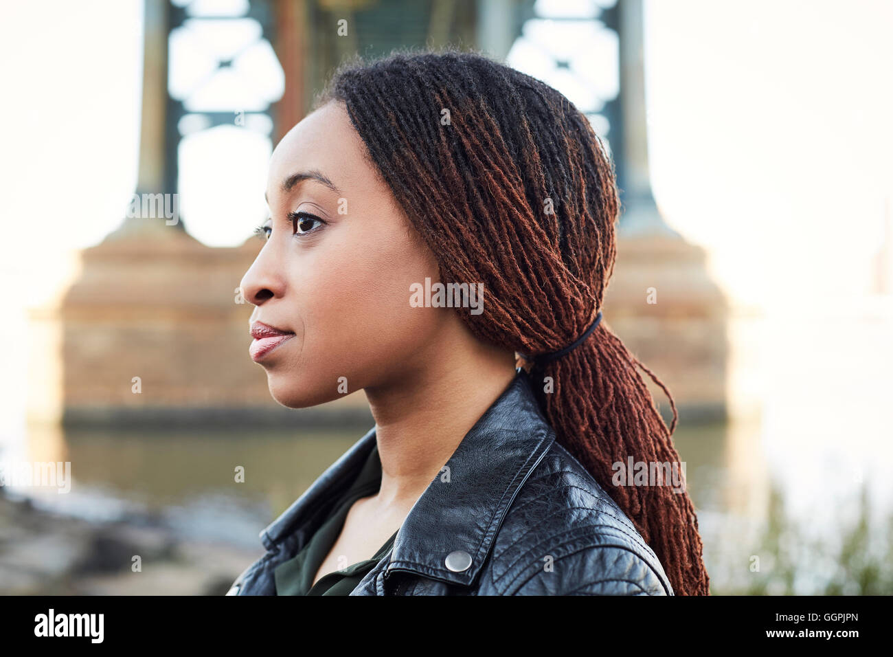 Profile of serious Black woman at bridge Stock Photo