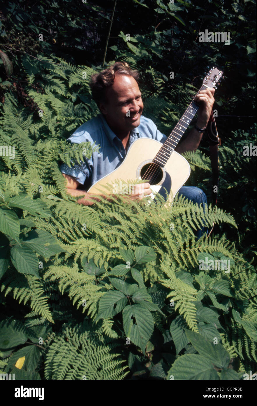 Author James Dickey, best known for his novel Deliverance, playing guitar  among dense foliage, June 23, 1969 Stock Photo - Alamy