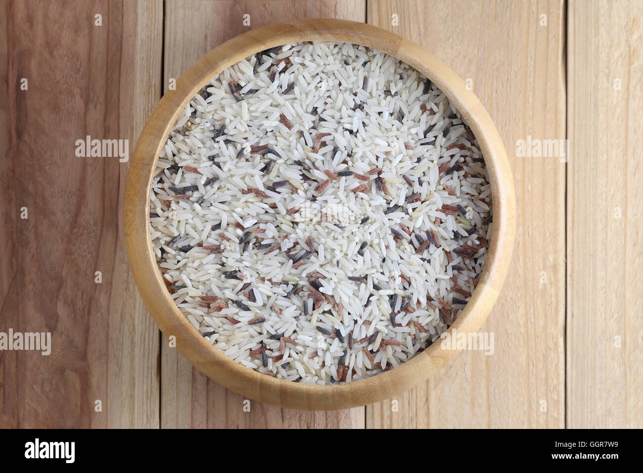 Organic rice in wooden bowl on wood background concept for nature food. Stock Photo