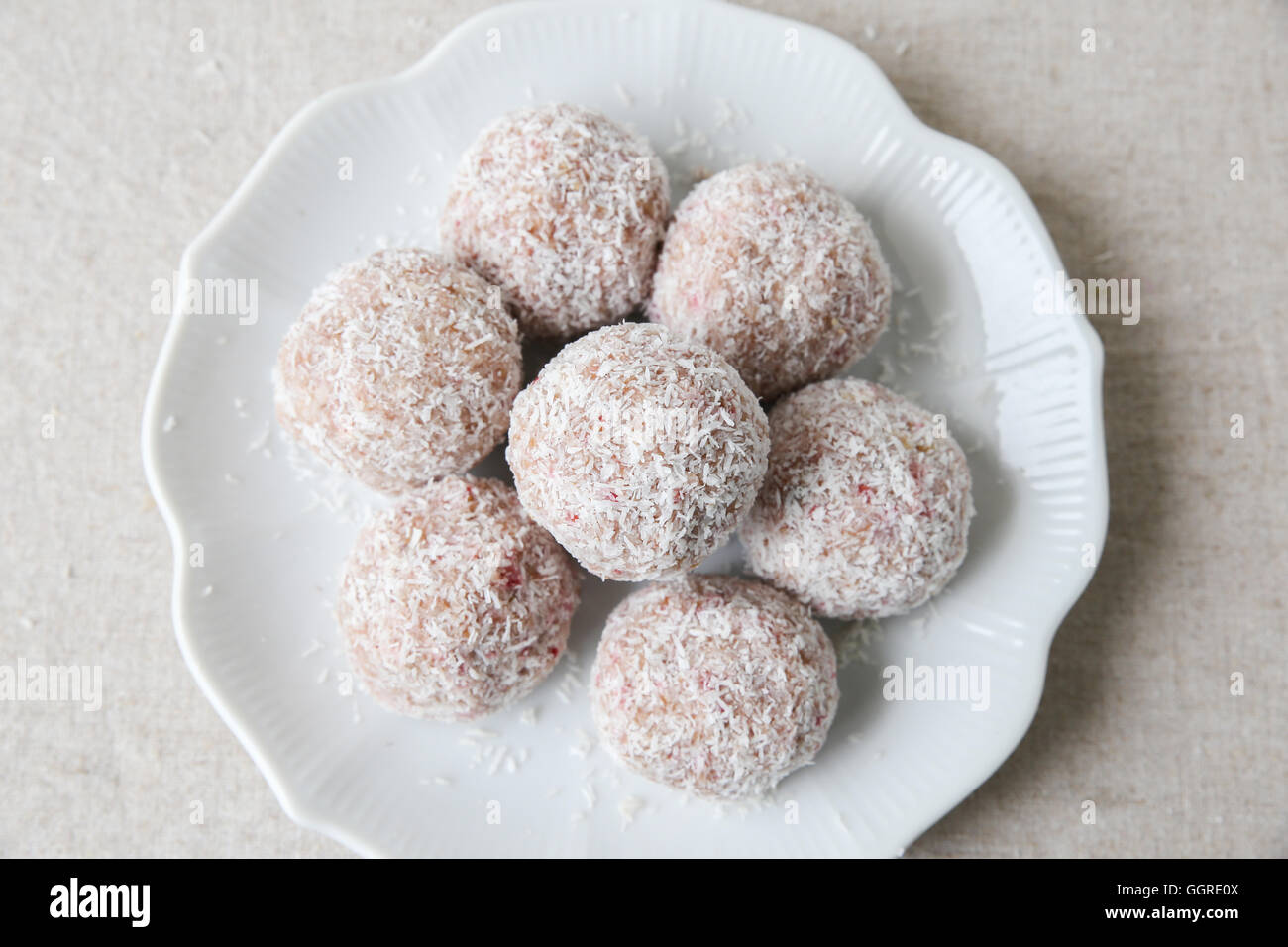 Homemade strawberry, date, cashew and coconut bliss ball on vintage plate Stock Photo