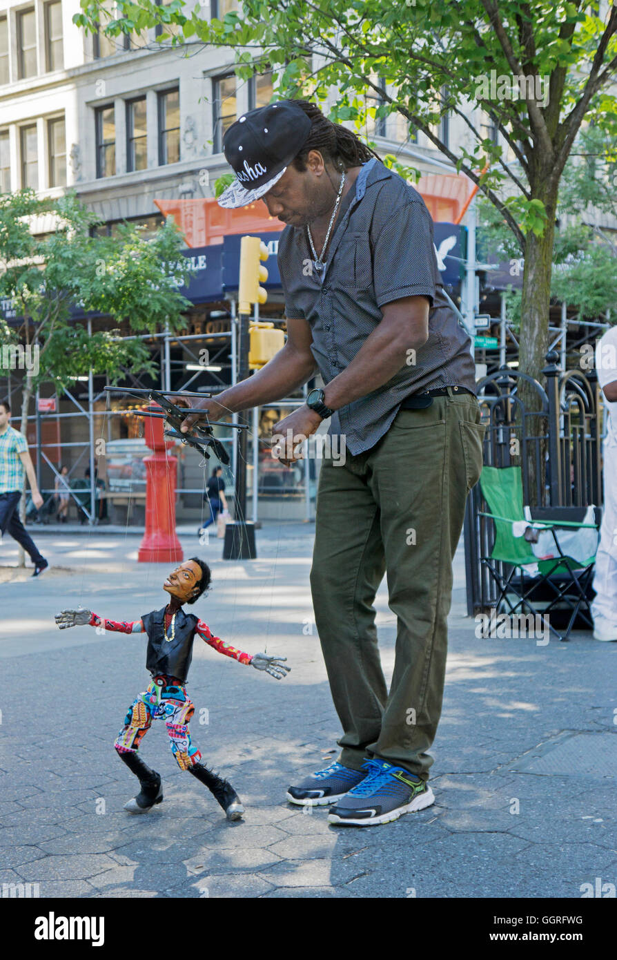 A marionette puppeteer with his dancing puppet in Union Square Park in Manhattan, New York City Stock Photo