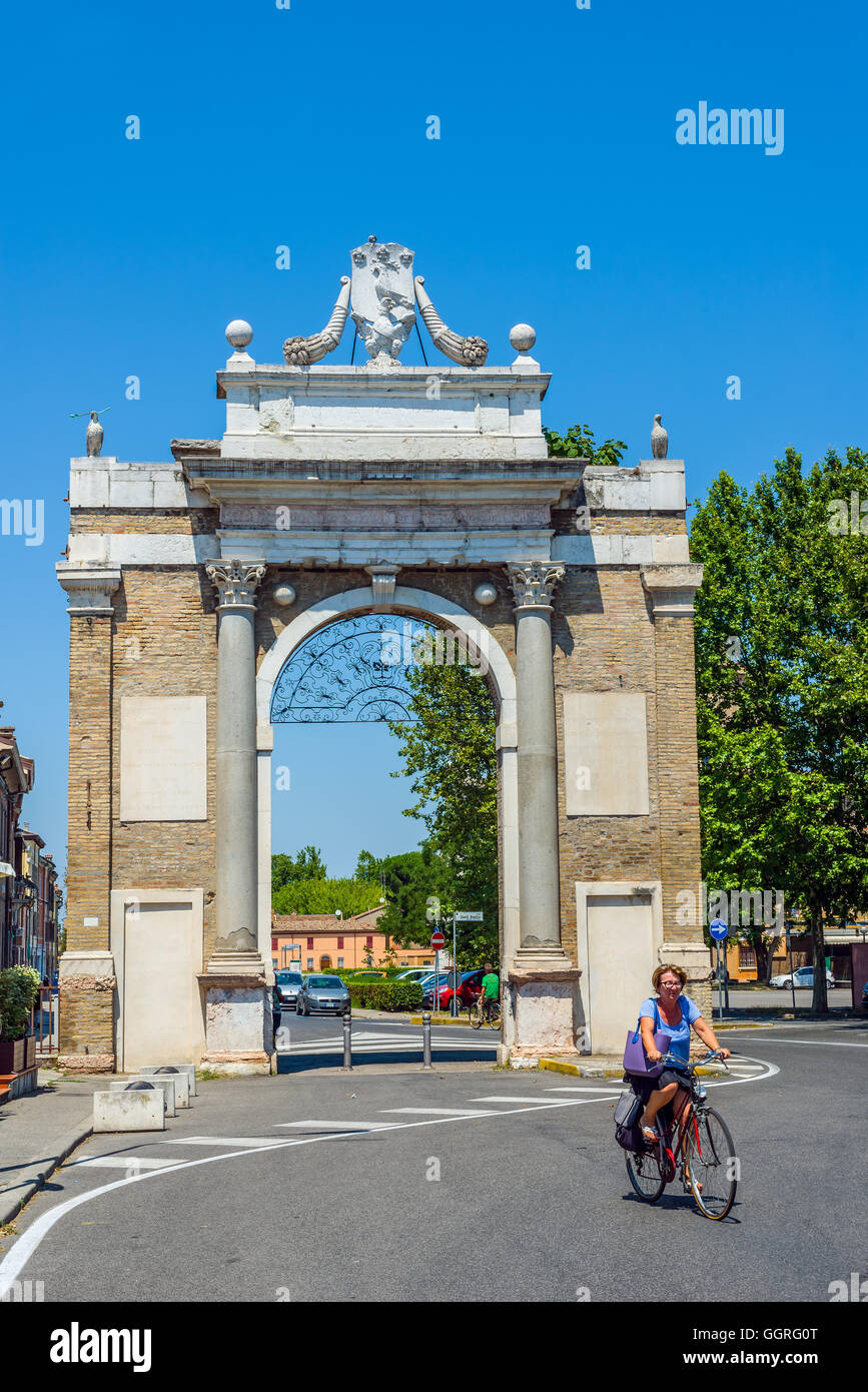 Cyclist crossing Via di Roma of Ravenna with Porta Nuova gate in background. Emilia-Romagna. Italy. Stock Photo