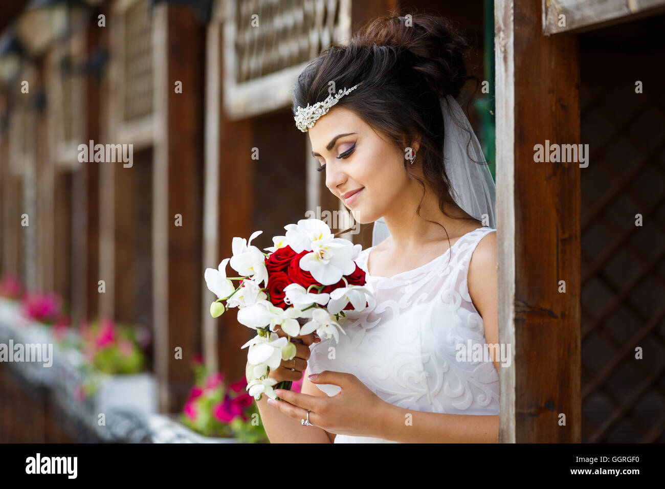 Beautiful bride with bouquet against the wooden background Stock Photo