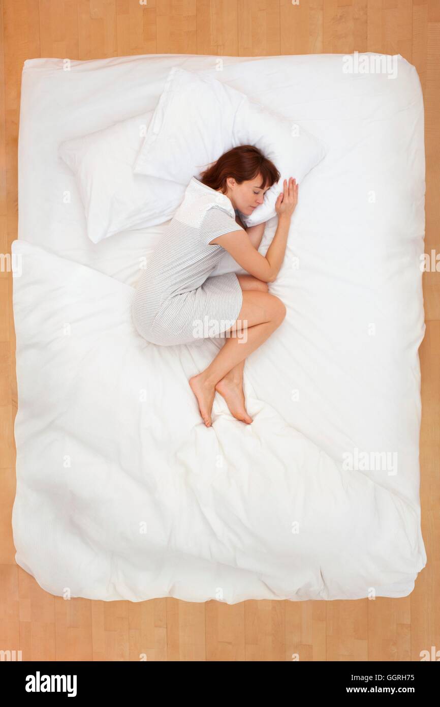 Mid adult woman lying in bed, asleep Stock Photo Alamy