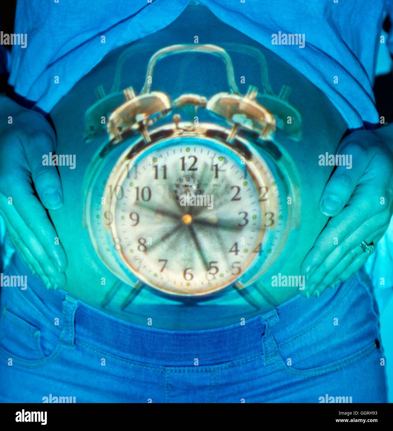 Alarm clock ringing and pregnant woman touching tummy Stock Photo Alamy