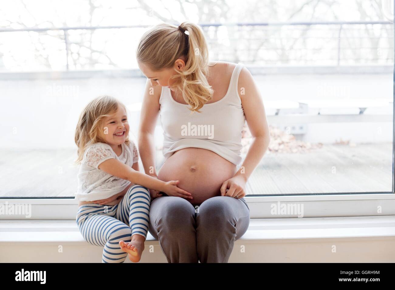 Girl touching pregnant mothers belly hi-res stock photography and images -  Alamy