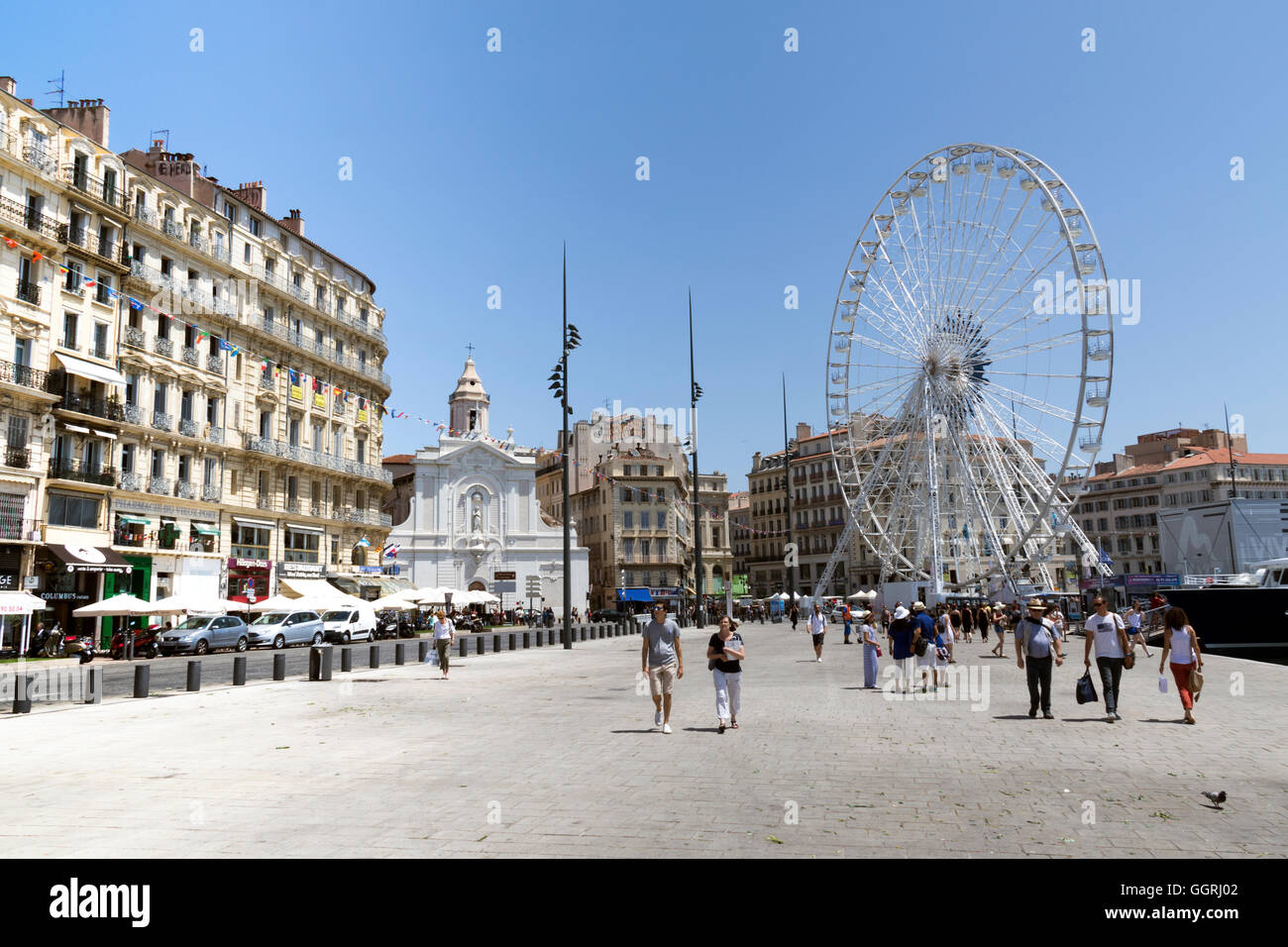 The centre of Marseilles' old port and harbour showing the ferris wheel and Saint-Ferreol Cathedral Stock Photo