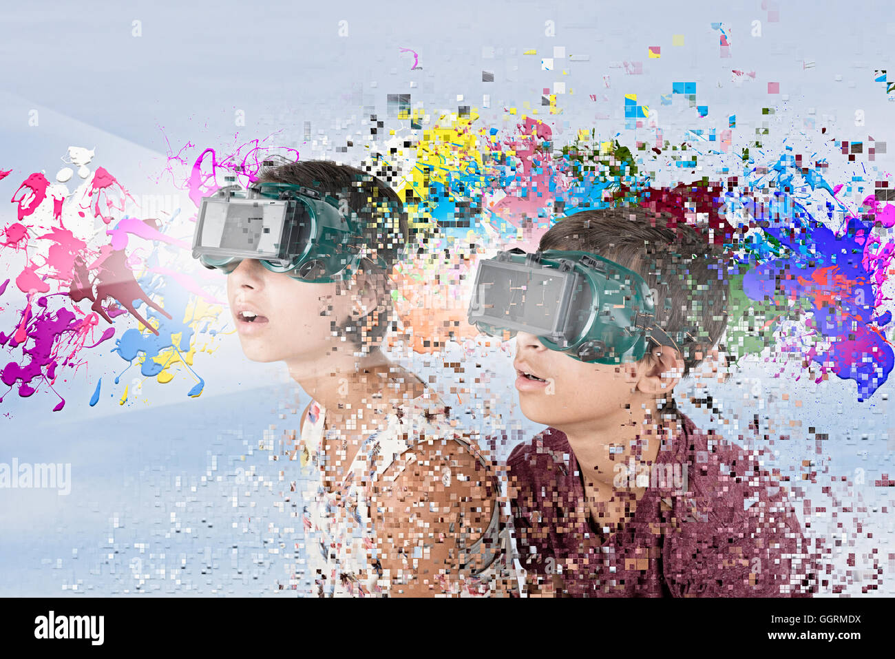 Mixed Race brother and sister watching paint splatter with VR goggles Stock Photo