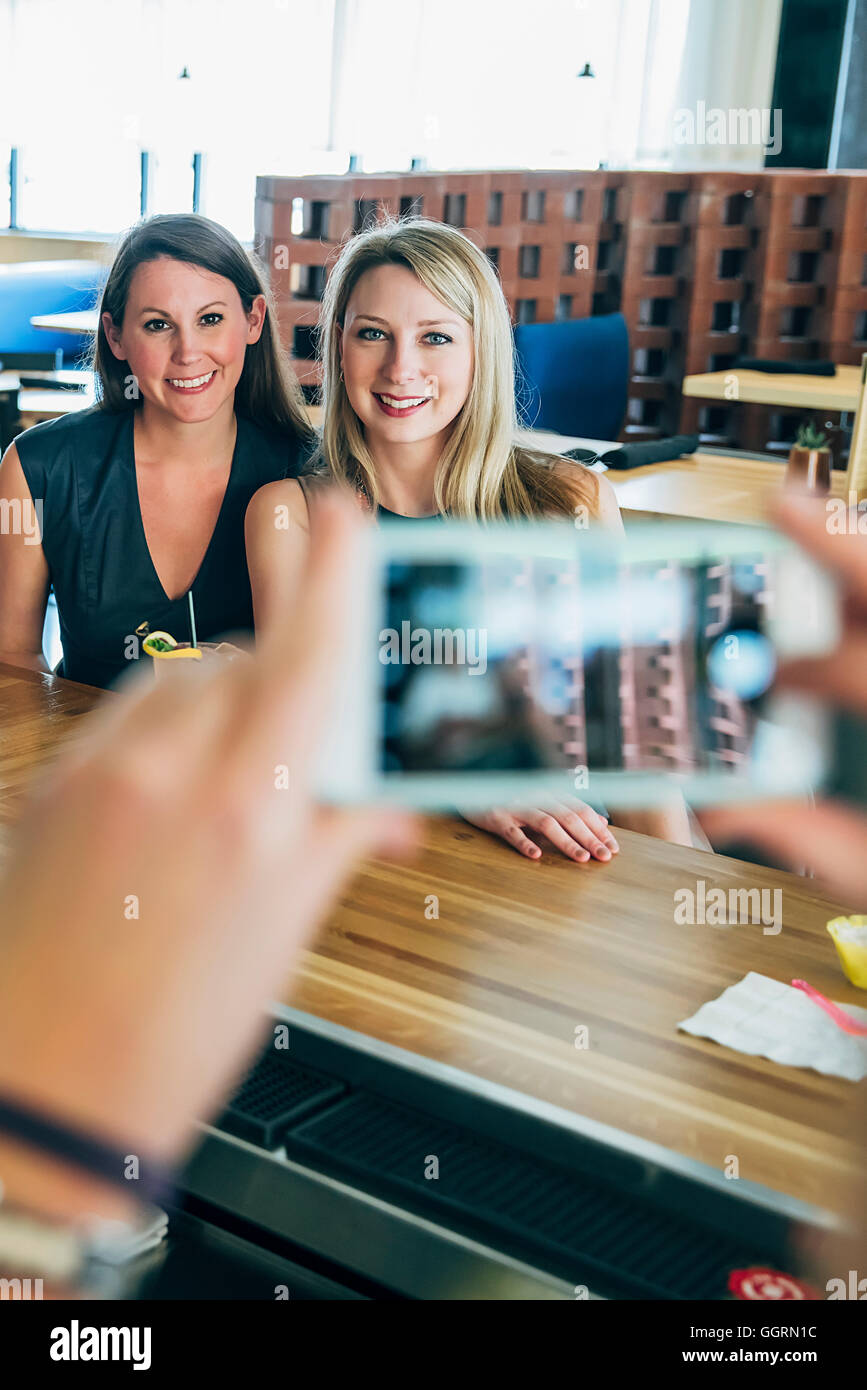 Caucasian bartender taking cell phone photograph of customers Stock Photo