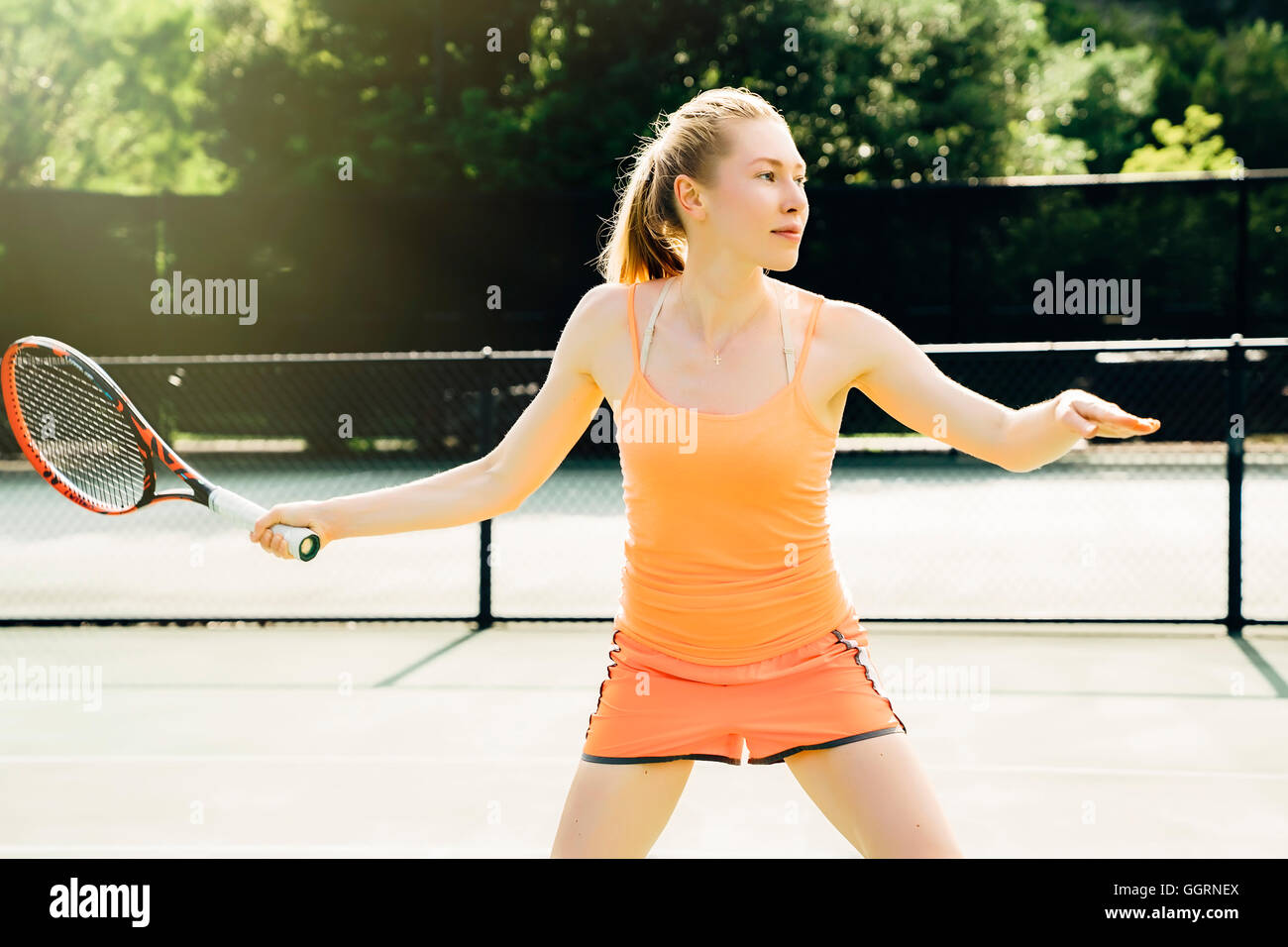Caucasian woman swinging tennis racket on tennis court Stock Photo - Alamy