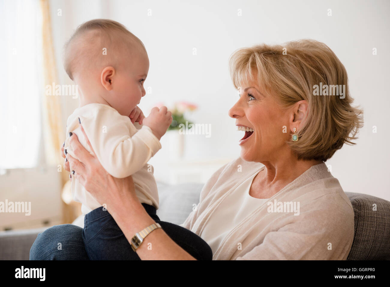 Caucasian grandmother making a face at baby granddaughter Stock Photo