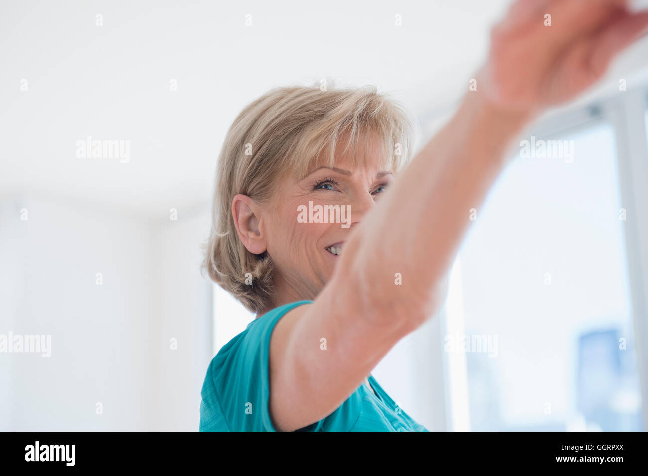 Older Caucasian woman with arms outstretched Stock Photo