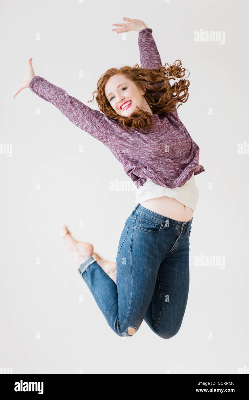 Caucasian woman jumping for joy Stock Photo
