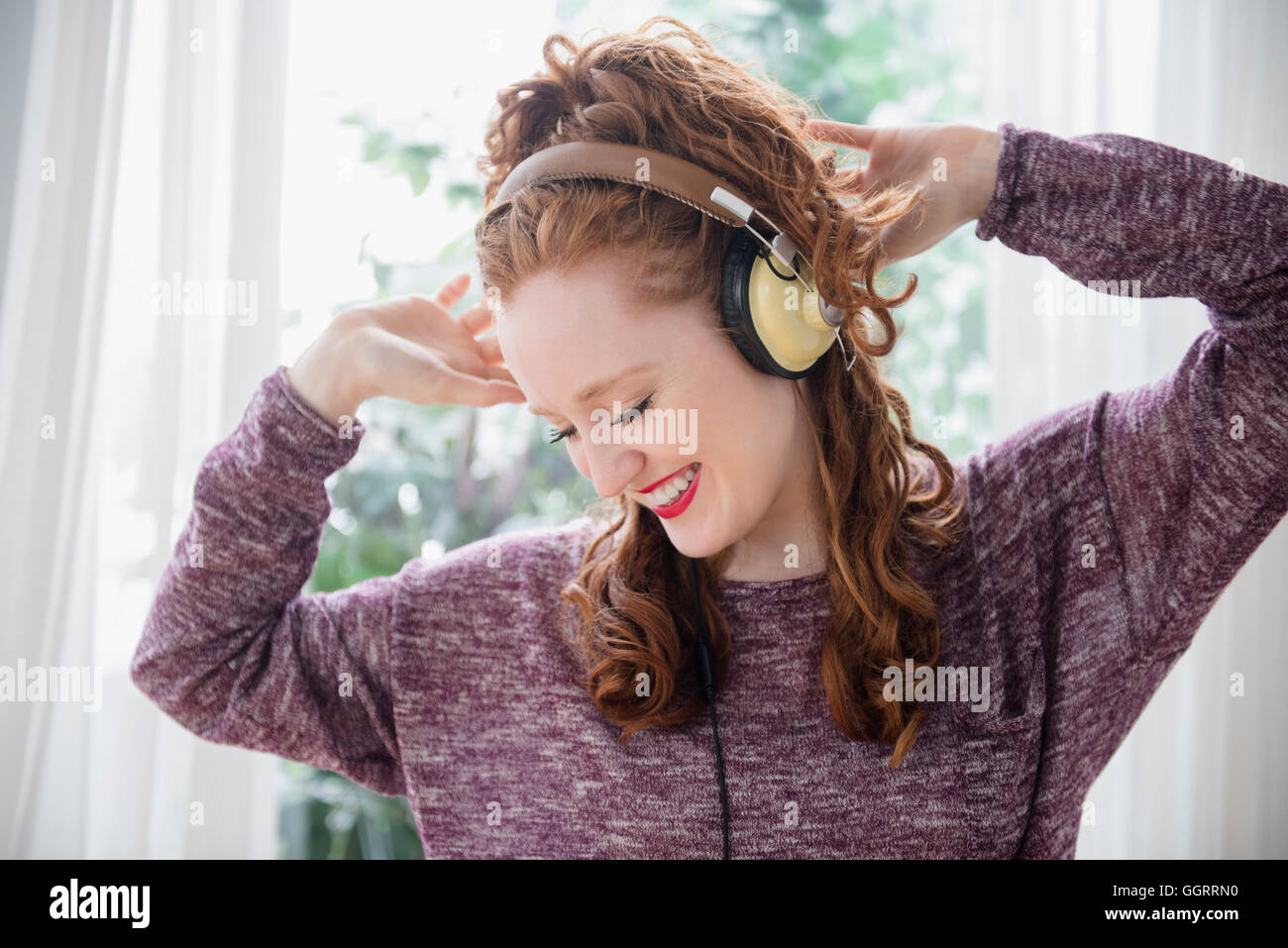 Caucasian woman listening to headphones and dancing Stock Photo