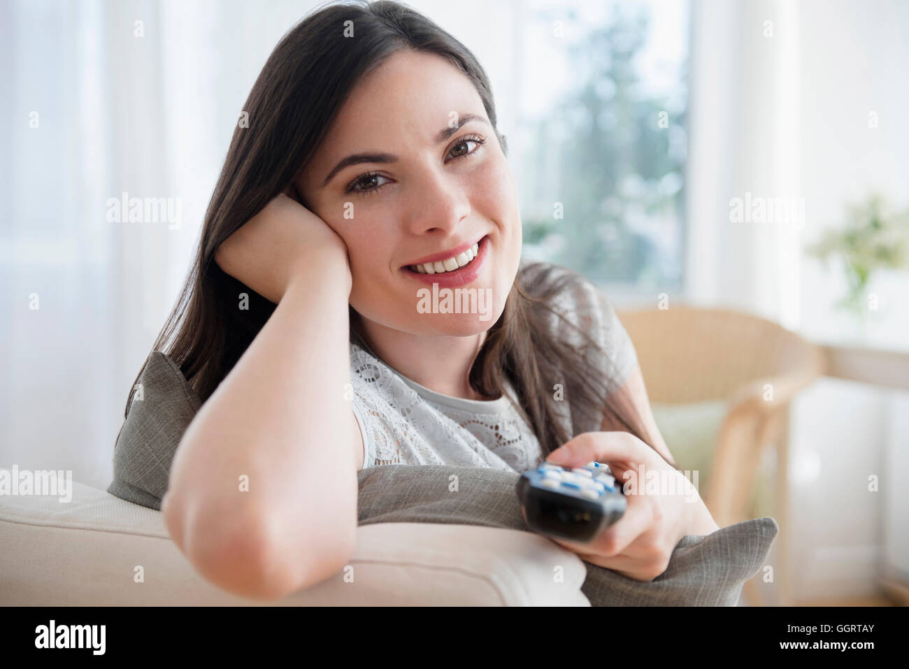 Caucasian woman aiming remote control Stock Photo