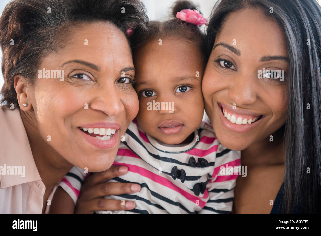 Black multi-generation family posing cheek to cheek Stock Photo