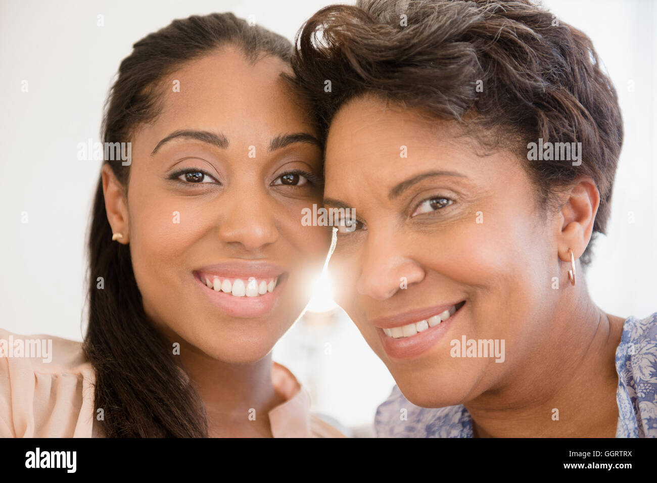 Smiling Black women posing cheek to cheek Stock Photo