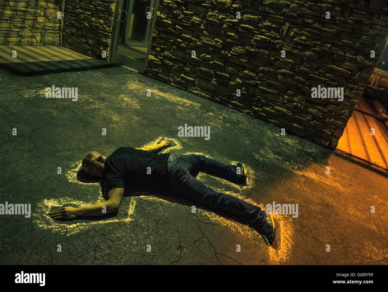 Chalk outline of body of Caucasian victim on pavement Stock Photo