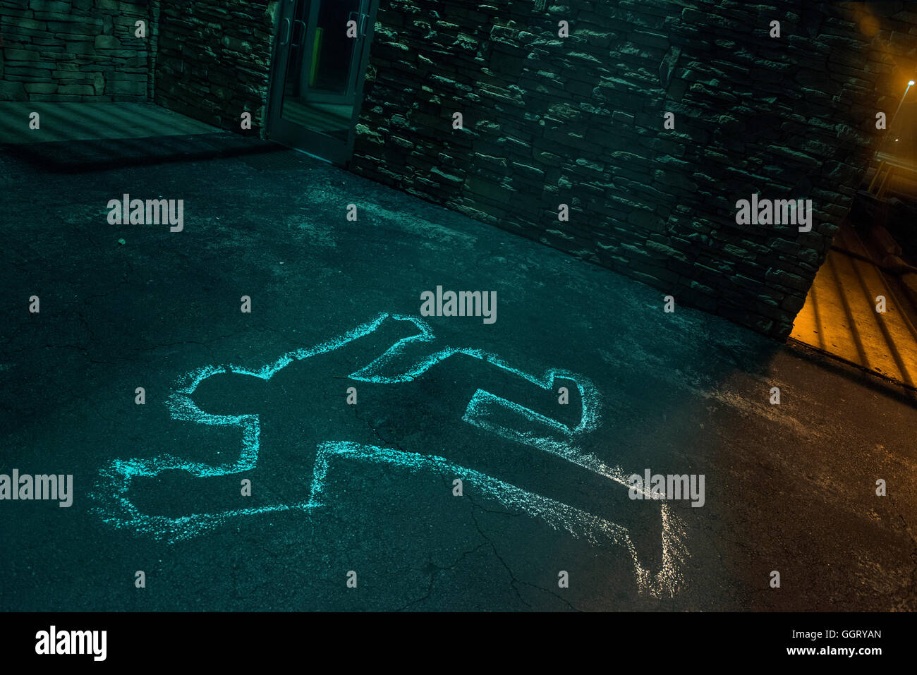 Chalk outline of body of victim on pavement Stock Photo
