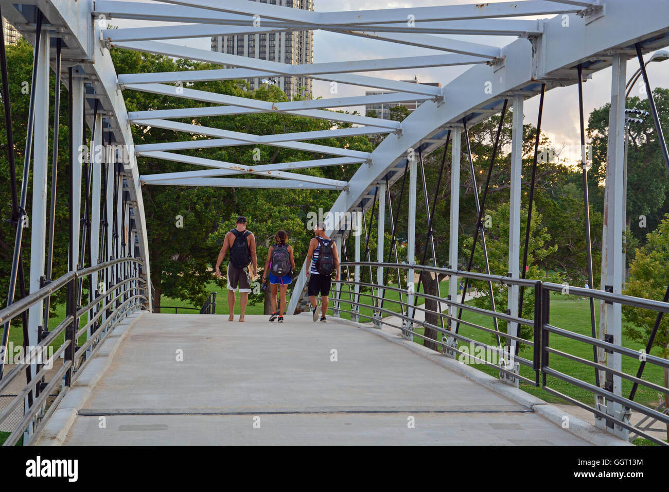 Friends walk home across the pedestrian bridge over Lake Shore Drive leading from Lincoln Park to the North Avenue Beach. Stock Photo