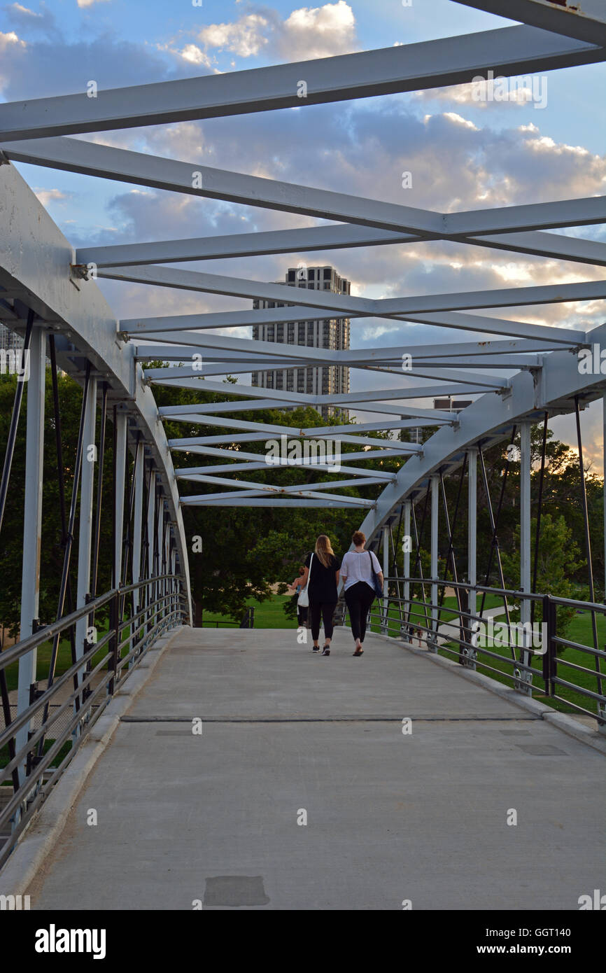 Two young women walk across the pedestrian bridge over Lake Shore Drive leading from Lincoln Park to the North Avenue Beach. Stock Photo