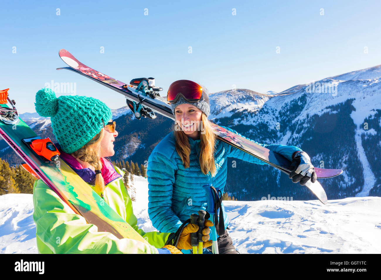 Women carrying skis on snowy mountain Stock Photo