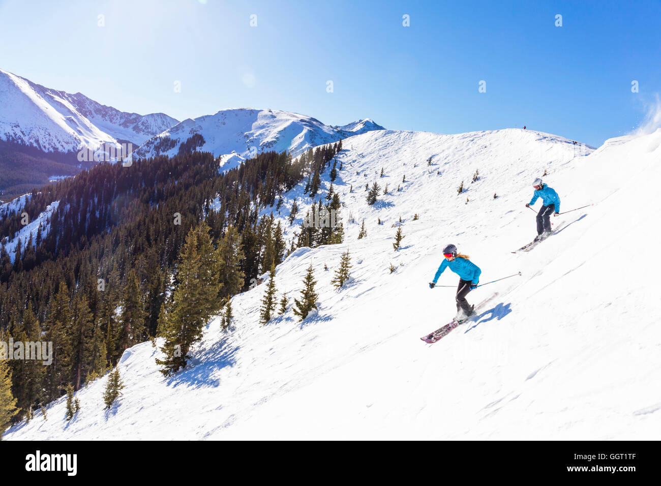 Couple skiing on snowy mountain slope Stock Photo