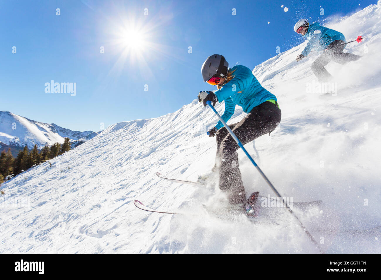 Couple skiing on snowy mountain slope Stock Photo
