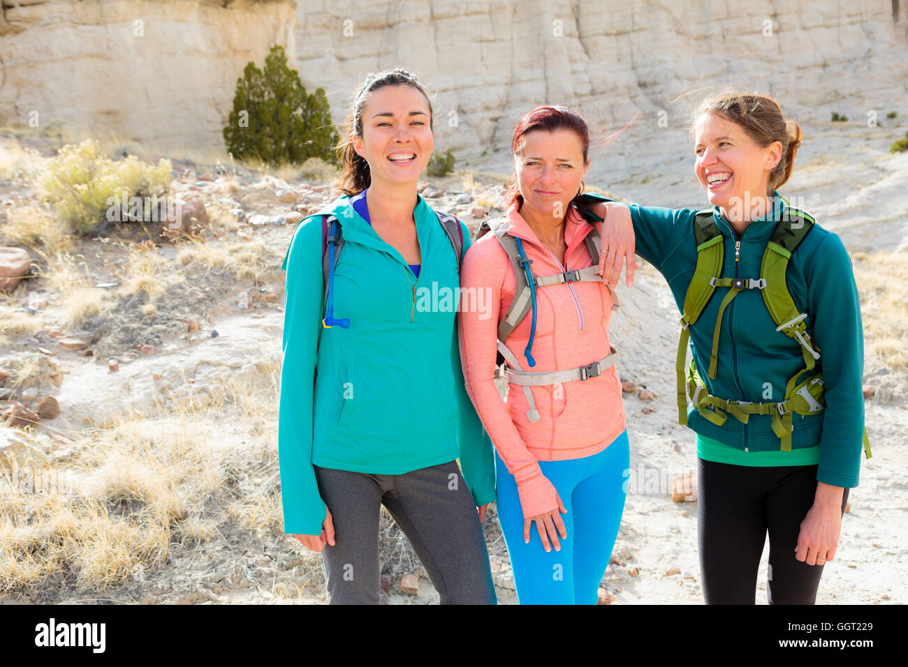 Confident women standing in canyon wearing backpacks Stock Photo