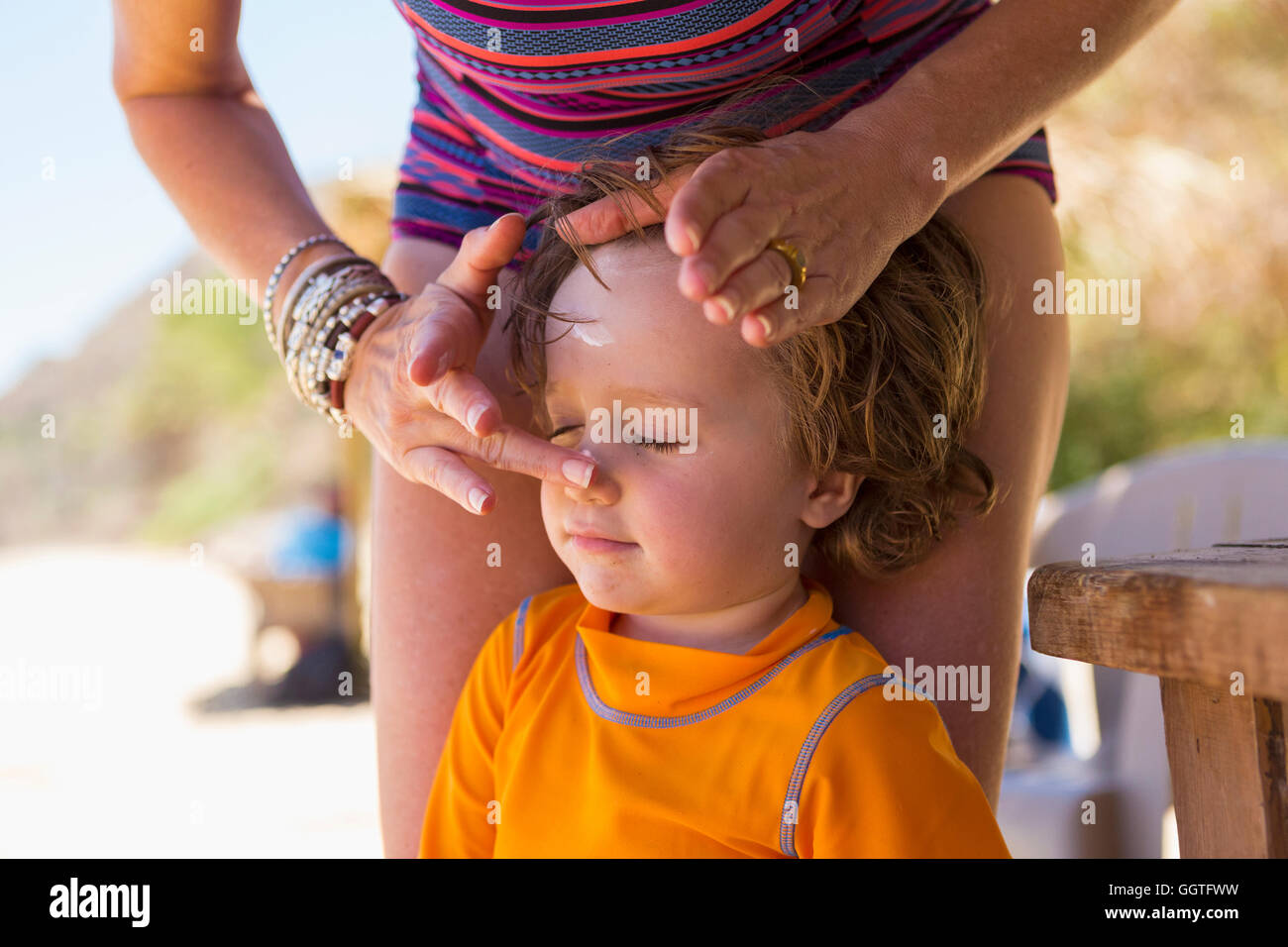 Caucasian mother applying sunscreen to face of son Stock Photo