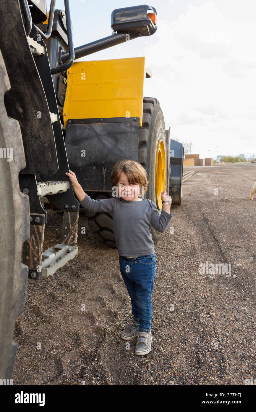 Caucasian boy holding ladder on tractor Stock Photo