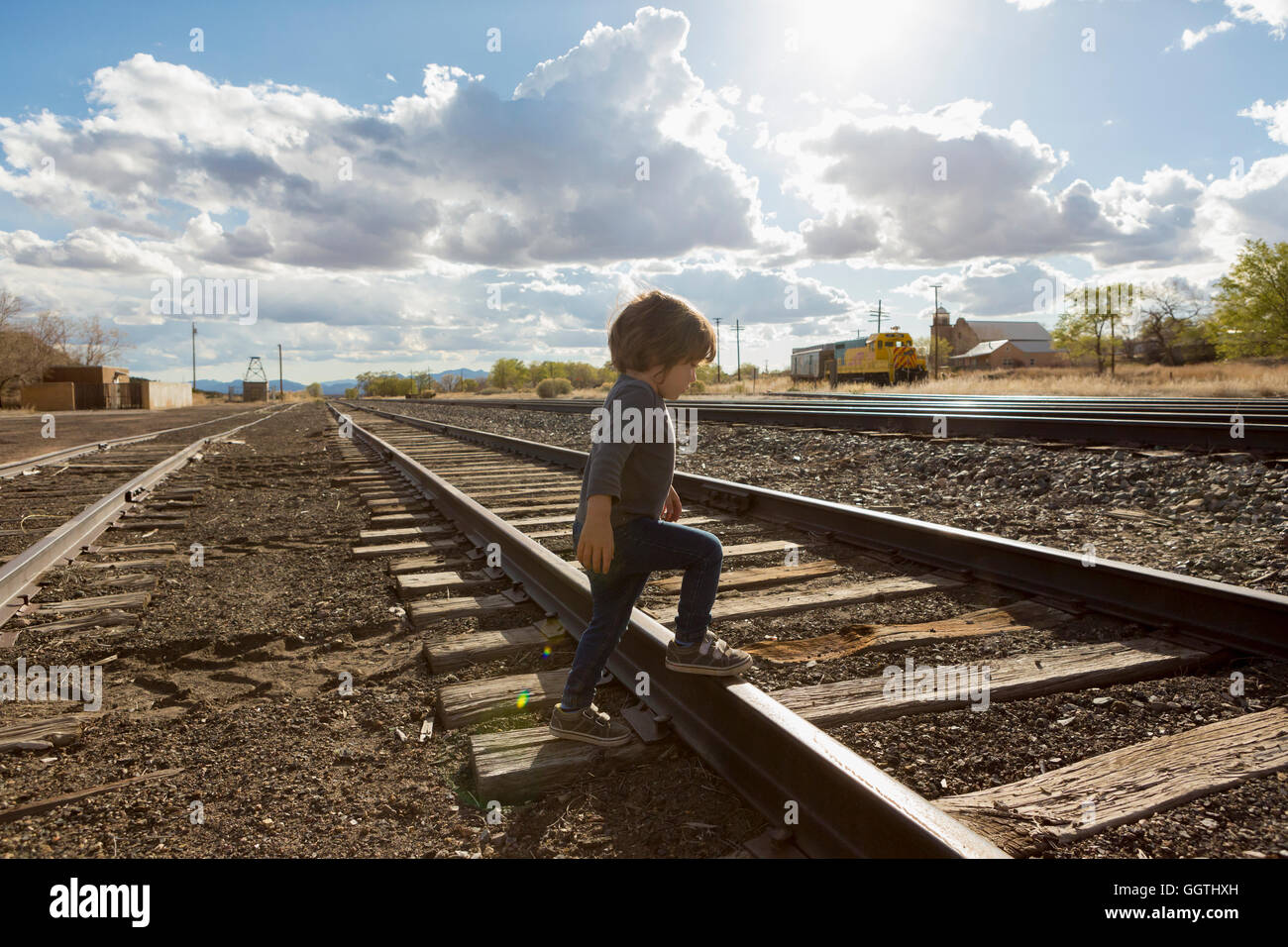 Caucasian boy crossing railroad tracks Stock Photo