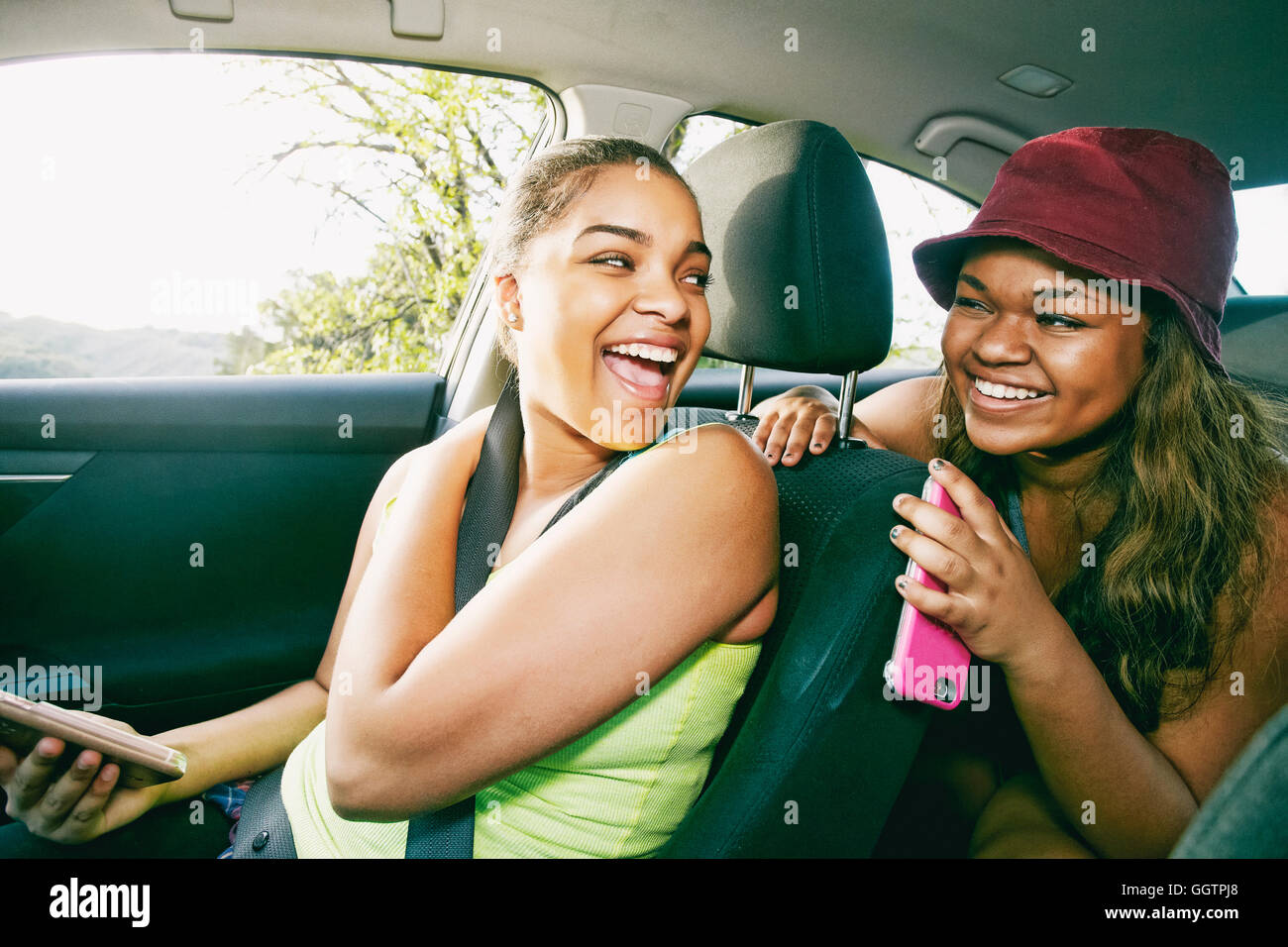 Mixed Race sisters laughing in car Stock Photo