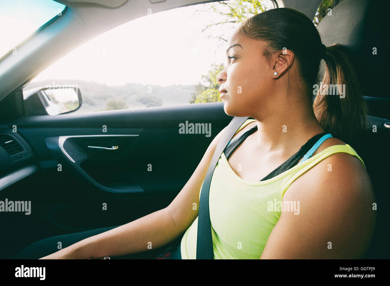 Mixed Race woman daydreaming in car Stock Photo