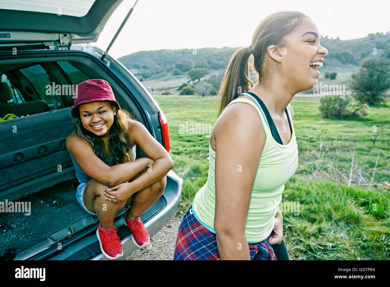 Mixed Race at hatch of car laughing Stock Photo