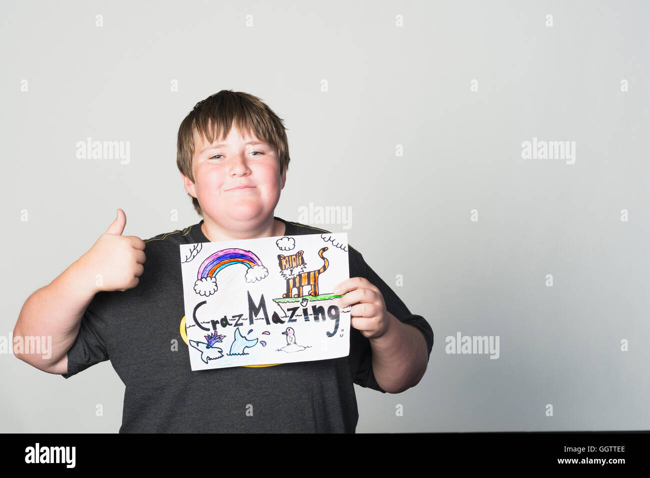 Boy holding sign gesturing thumbs-up Stock Photo