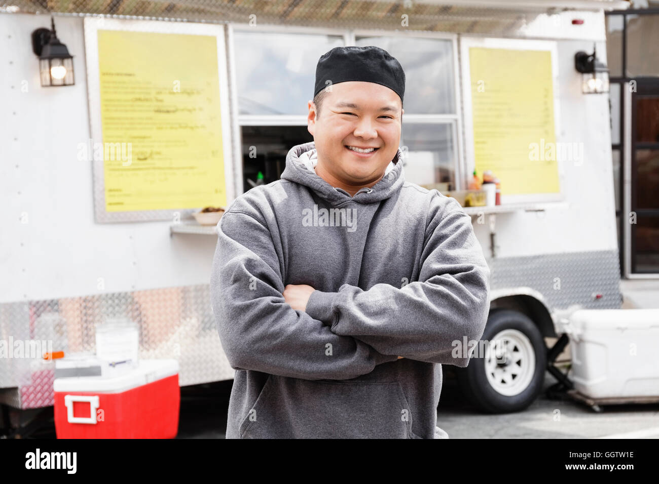 Proud Asian man standing at food truck Stock Photo