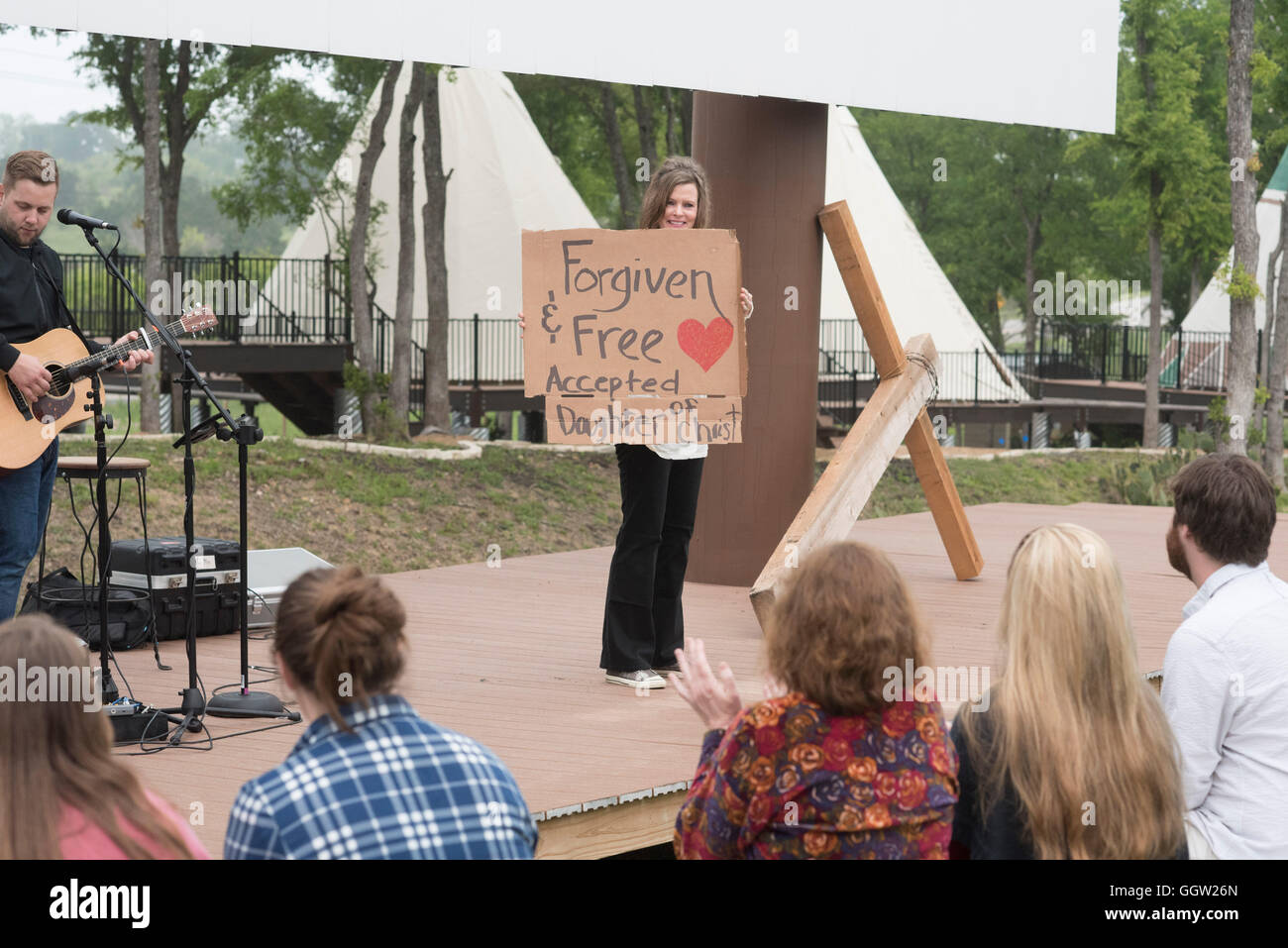 Participants in contemporary Easter service display their faith testimonies on cardboard signs at Community First! Village Stock Photo