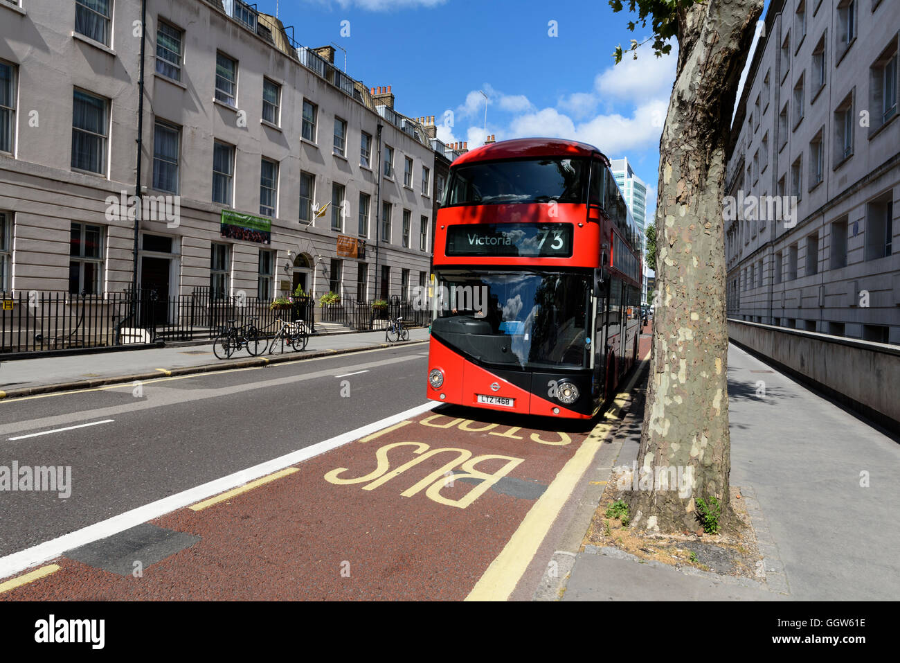 Red double decker London bus traveling on the bus lane. Stock Photo