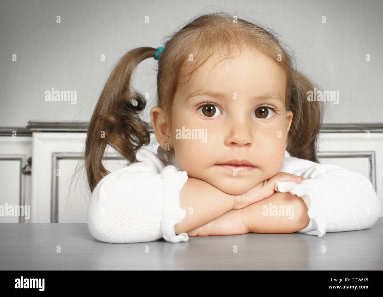Porteait of serious dreaming child girl, in room Stock Photo