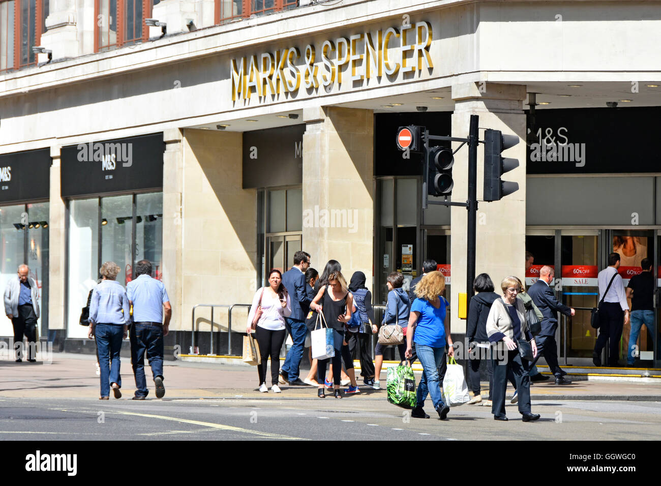 West End shoppers in Oxford Street outside entrance to Marks and Spencer flagship Marble Arch shopping department store in London England UK Stock Photo