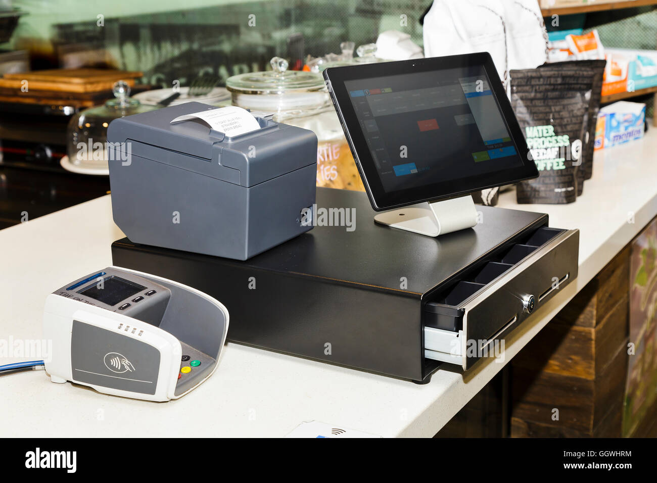 POS terminal consisting of Tablet computer with touchscreen, mobile printer and pay terminal on a cashbox at a counter Stock Photo