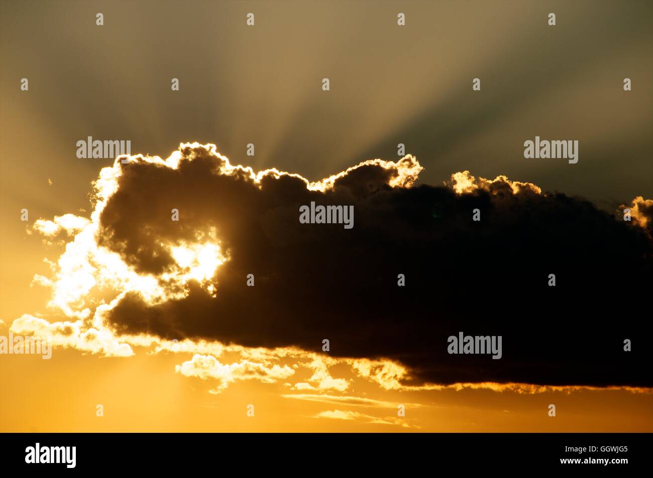 Large cloud obscuring sun at sunset. Stock Photo