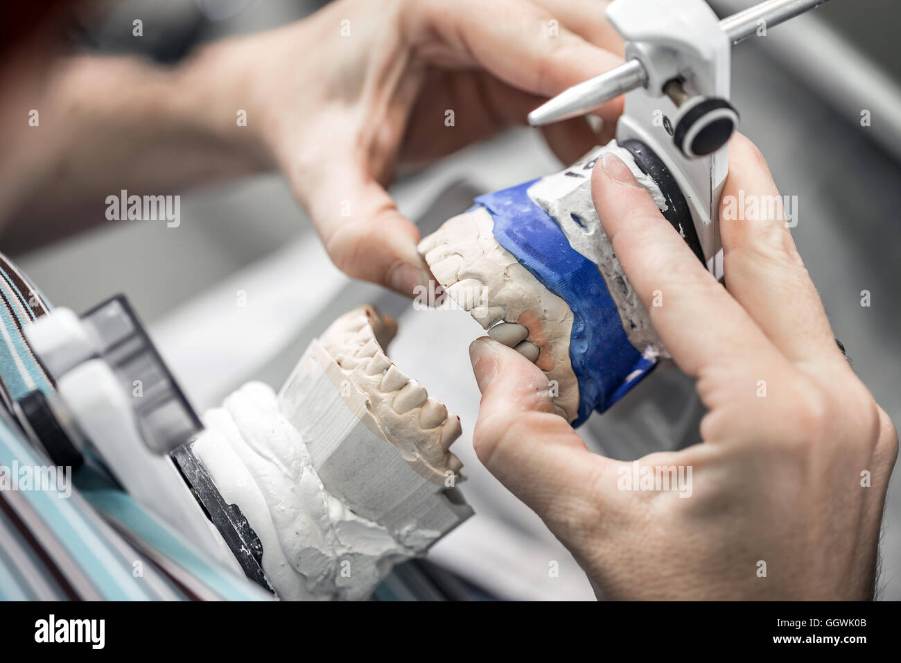 Dental technician working with tooth dentures at prosthesis laboratory
