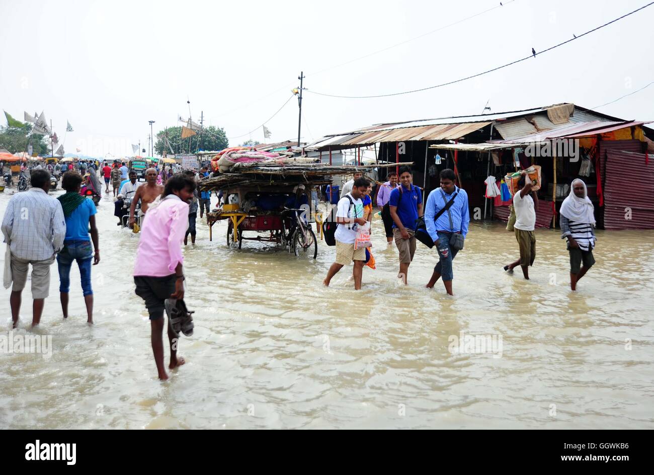people wades trough a flooded road submerged with water of river ganga GGWKB6