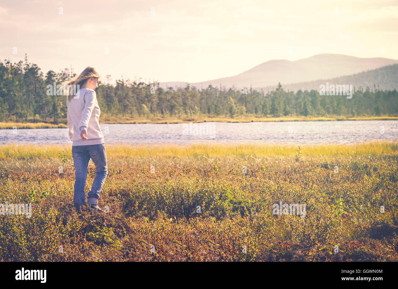 Woman Traveler walking alone Travel Lifestyle concept Summer vacations outdoor tundra forest on background Stock Photo
