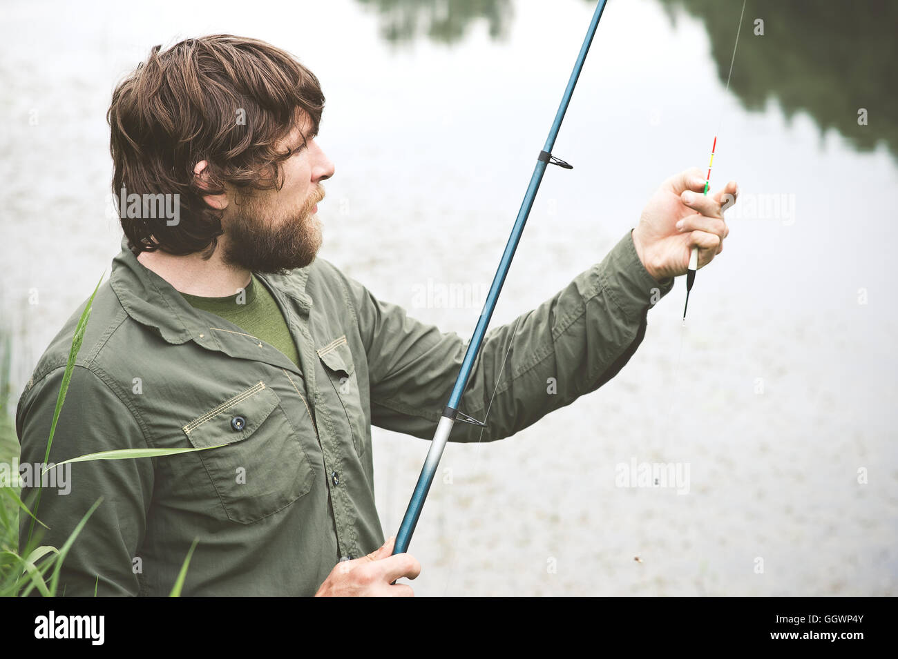 Young Man Fisherman bearded fishing with rod Lifestyle Travel