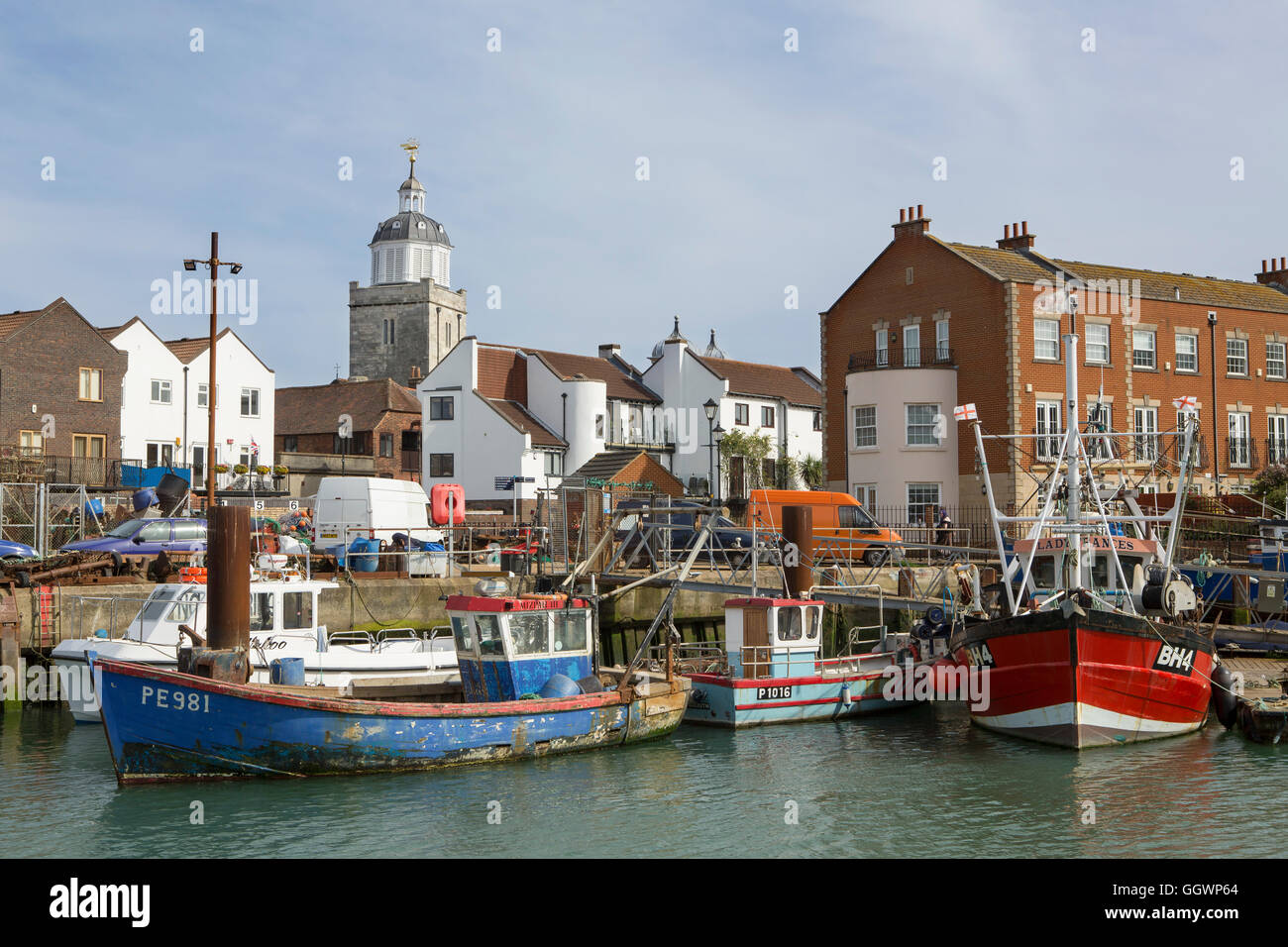 Crowded fishing port in old Portsmouth. Row of boats tied up in the Camber Docks. The cathedral tower in the background. Stock Photo