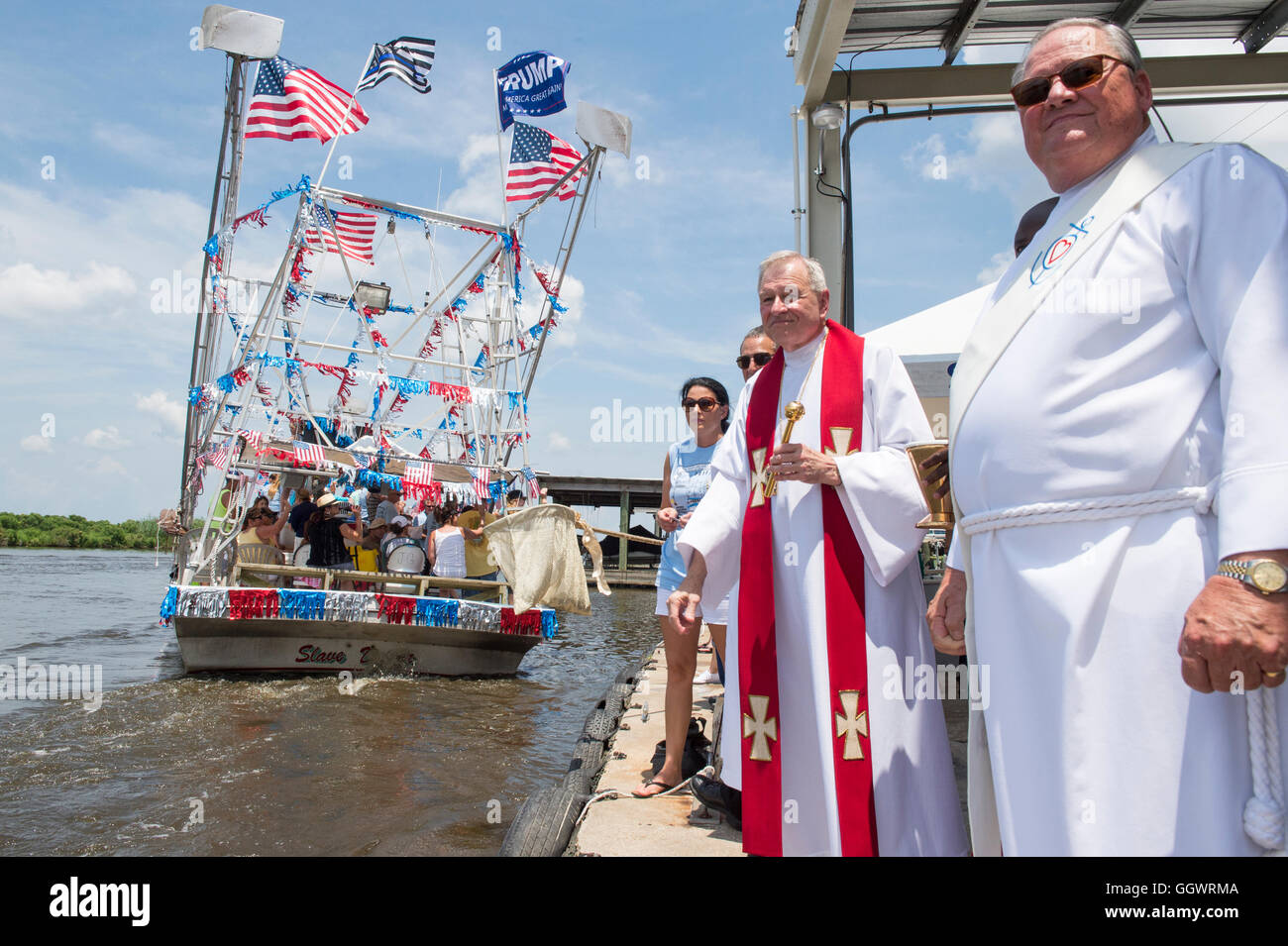 Delacroix, La. Saturday, Aug. 6, 2016. Archbishop Aymond (center) watches for the approaching boats for blessing. Stock Photo
