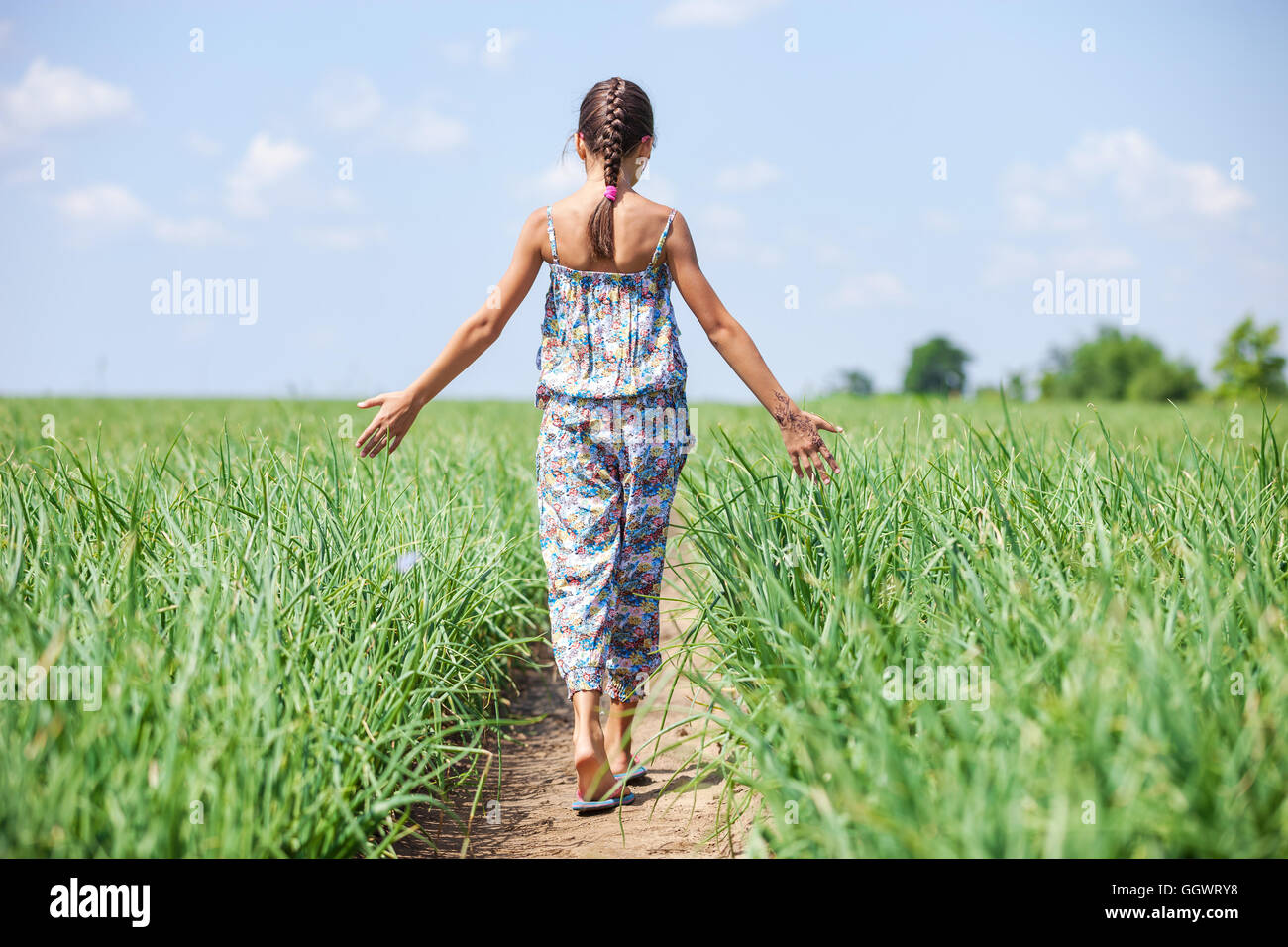 Young girl walking through field Stock Photo Alamy